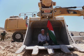 پیرمرد با پرچم فلسطین در داخل بولدوزر اسرائیل