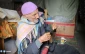 Golden fingers weaving hats using a wooden spindle