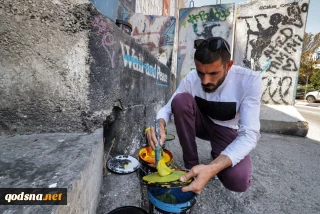 Palestinian artist paints murals on Israeli barrier