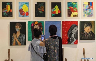 Visitors view artworks made by Palestinian children during exhibition in Gaza City
 2